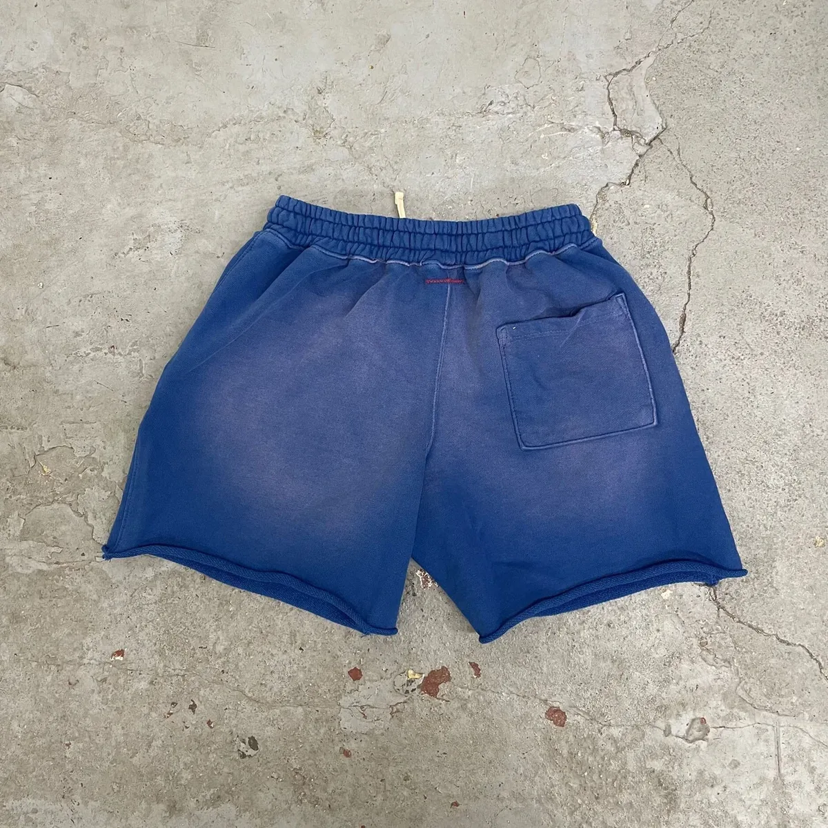 Back view of garment-dyed raw-hem sweat shorts